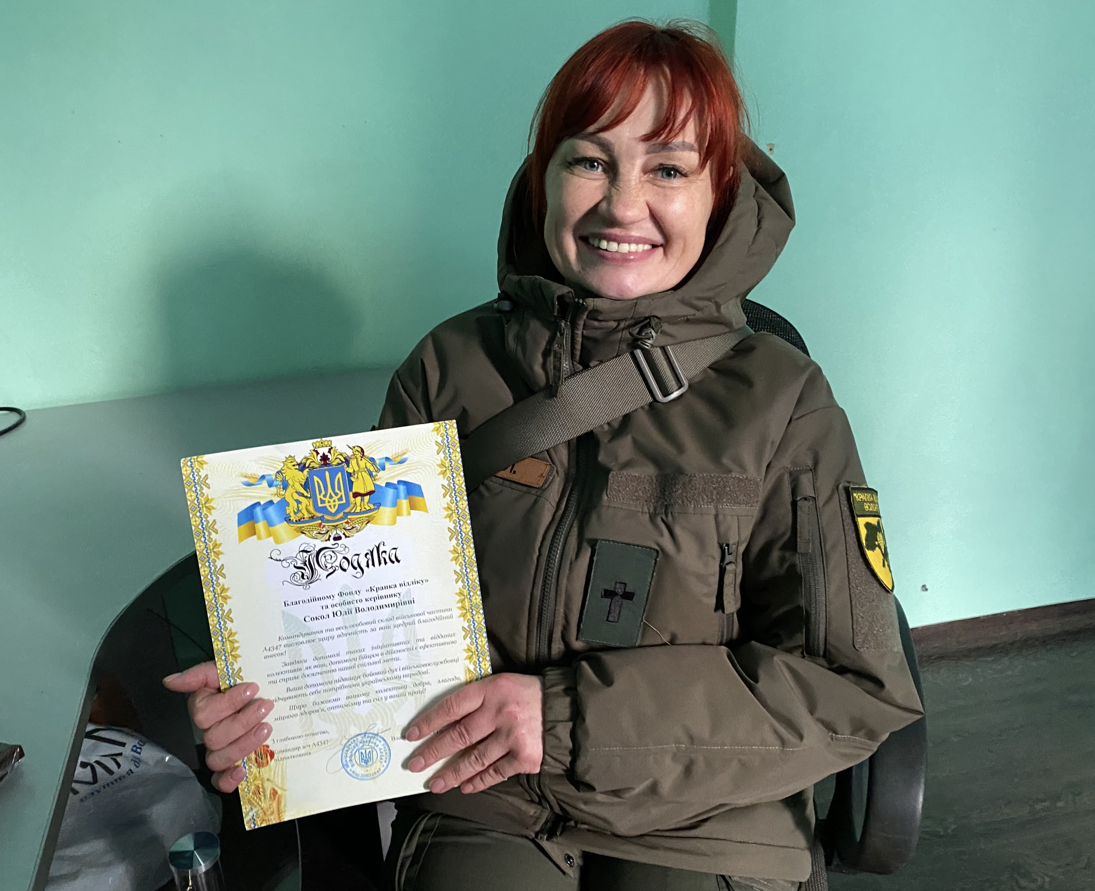 Sotilaspastori Yulia Sokol pitää yhteyttä sotilaisiin ja johtaa myös avustusjärjestöä. Kädessä on presidentiltä saatu kunniakirja.