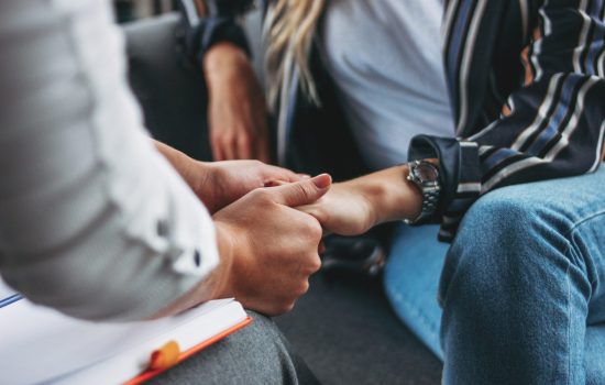 Woman support and help concept. Women hold each other's hands sitting in loft office